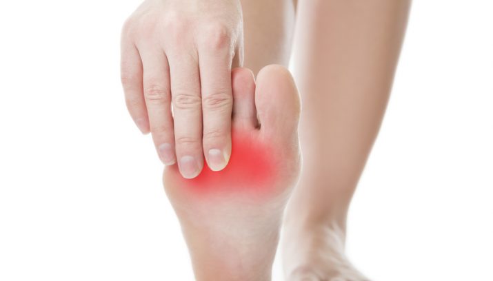 Pain in the foot. Massage of female feet. Pedicures. Isolated on white background.